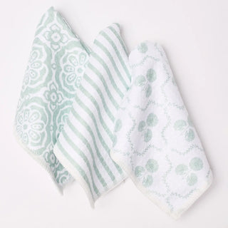 Three patterned towels in green and white on a light gray background