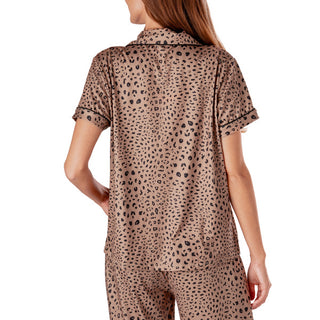 Woman wearing a leopard print pajama set on a white background