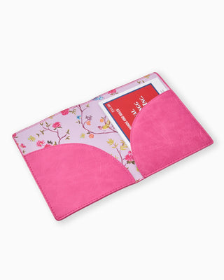 Pink fabric with floral pattern and a red book inside on a white background