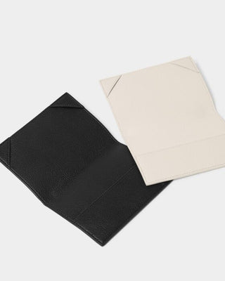 Black and beige leather sleeves on a light gray background