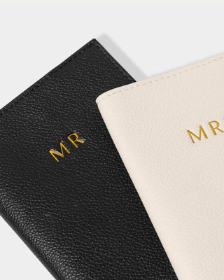 Black and beige leather journals with 'MR' initials on a light gray background