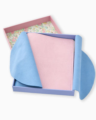 Two fabric swatches, one blue and one pink, in a floral-patterned box.