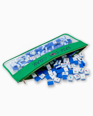 Green bag with blue and white tiles spilling out on a white background