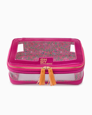 Pink travel case with clear top and gold tassels on a white background