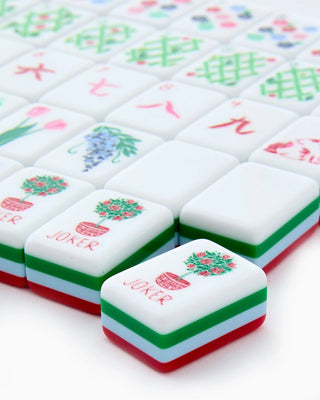 Close-up of colorful tiles with 'Joker' card on a white background