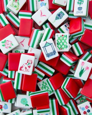 Assorted Mahjong tiles with various designs on a red background