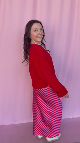 girl wearing a red sweater on a pink background