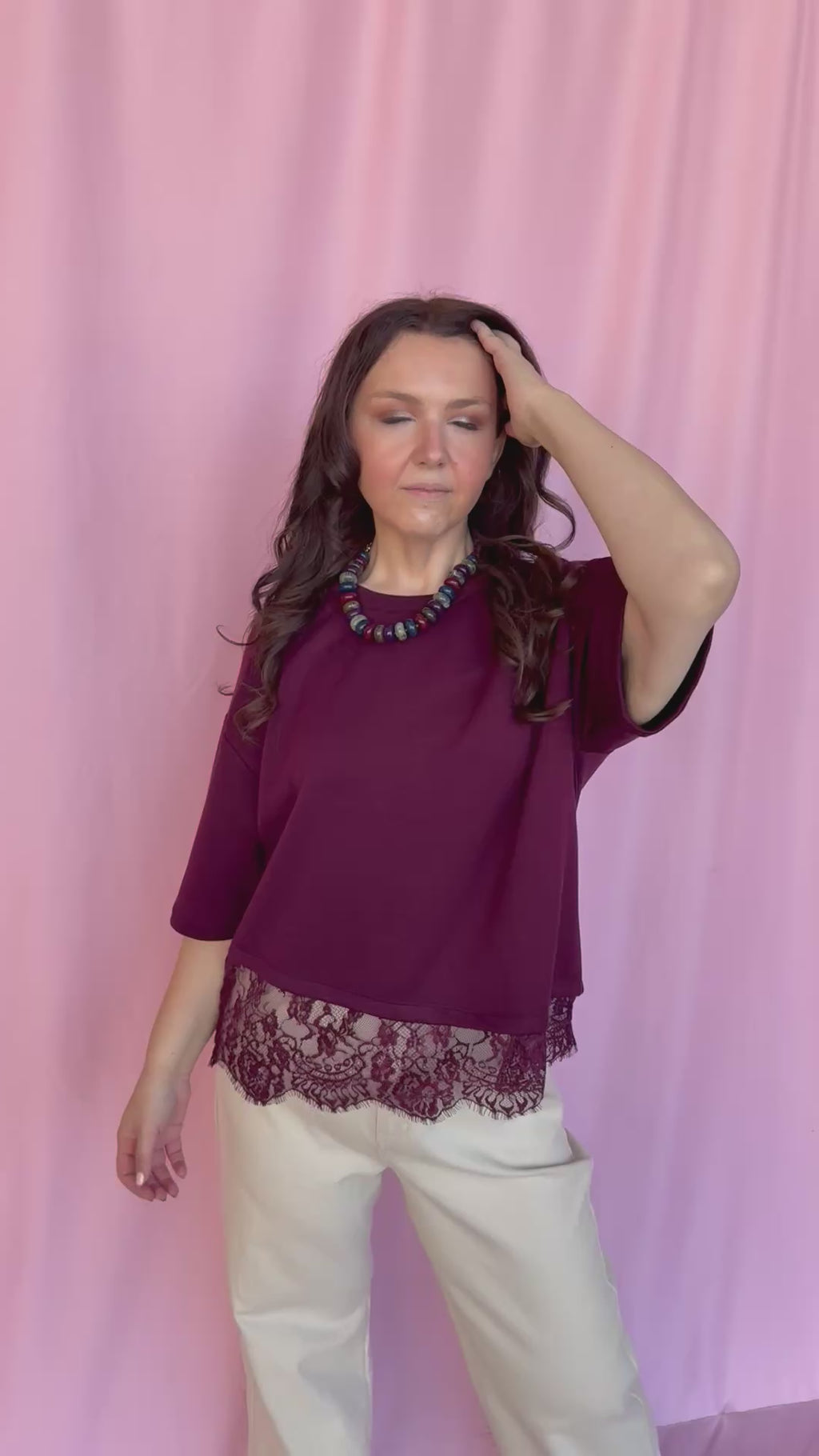 girl wearing red top on a pink background 