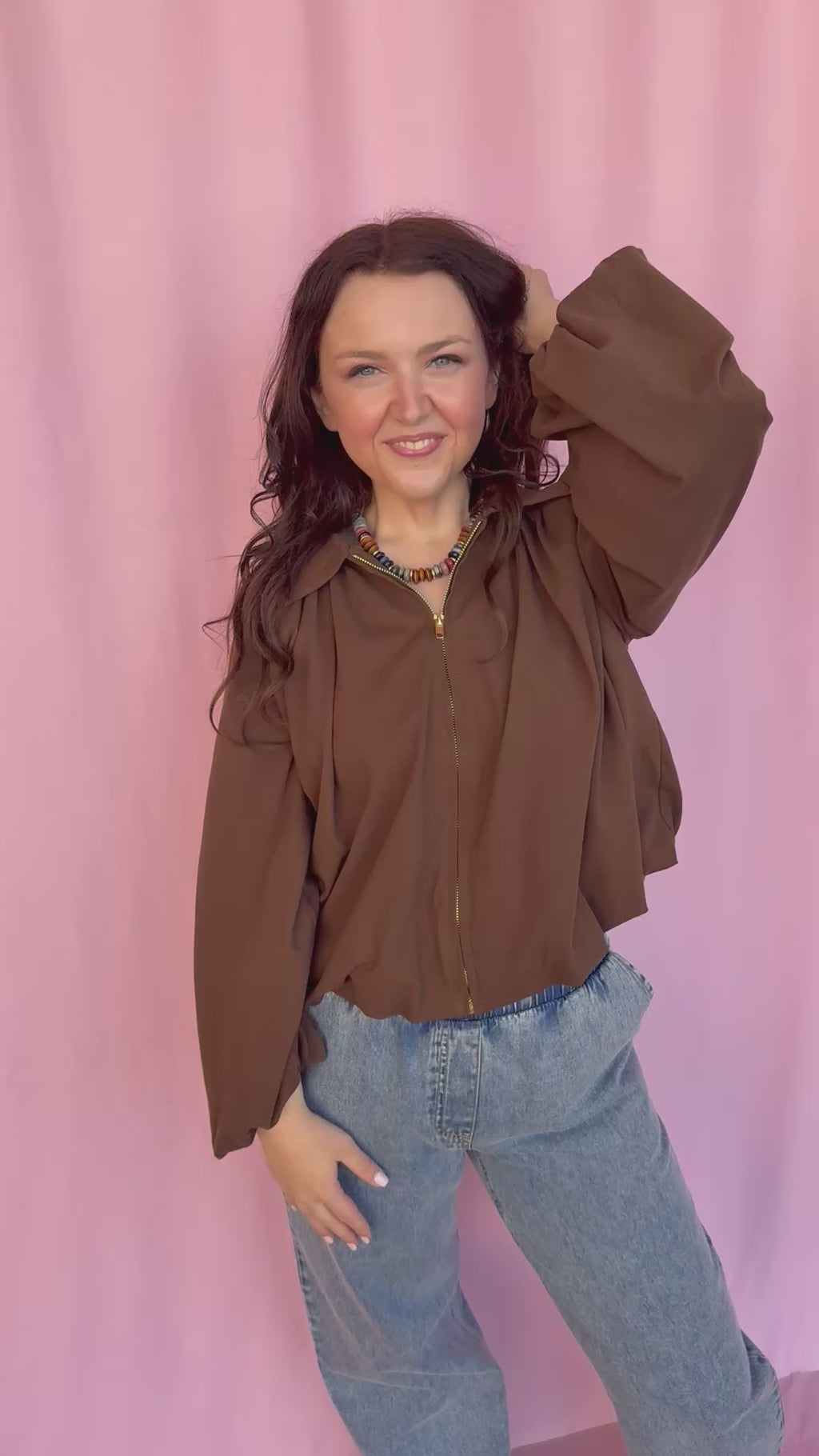 girl wearing a brown shirt on a pink background 