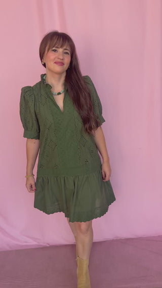 woman wearing a green dress on a pink background