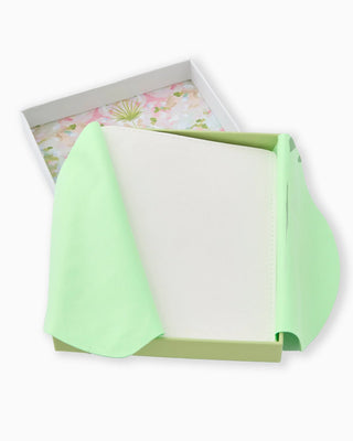 Green fabric with a floral patterned box in the background